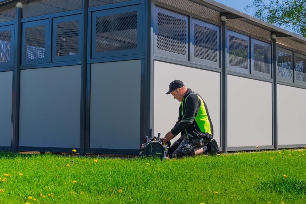 Medarbetare med verktygslåda i gräset